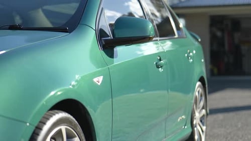 Side Profile of Green Sports Sedan In Afternoon