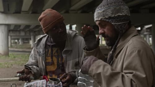Two Men Talking Underneath an Overpass Structure