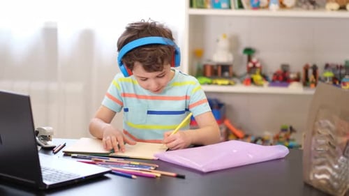 Boy with Headphones Doing Homework