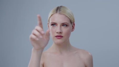 Portrait of Pretty Blonde Girl Pointing with Finger on a Virtual Touchscreen Closeup of Topless