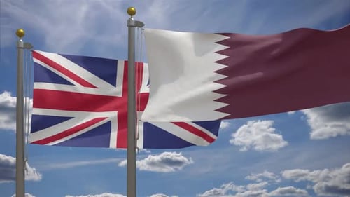 United Kingdom and Qatar Flags Waving Against Blue Sky
