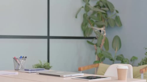 Young Businessman Coming to Office and Starting Work on Laptop