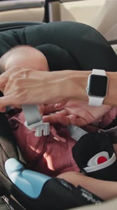 Infant Secured in Car Seat by Adult