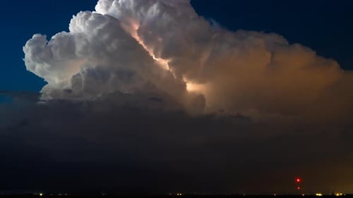 Relâmpago brilhando em uma nuvem de tempestade imponente sob o céu noturno estrelado Time Lapse