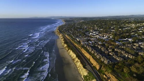 Drone flying over train tracks on the coastline of San Diego, sunny evening in CA,US