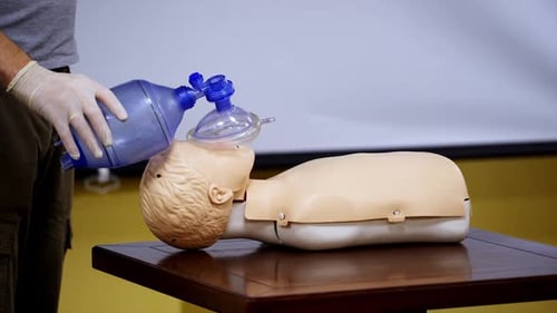 Medical Professional Demonstrates Rescue Breathing on Mannequin