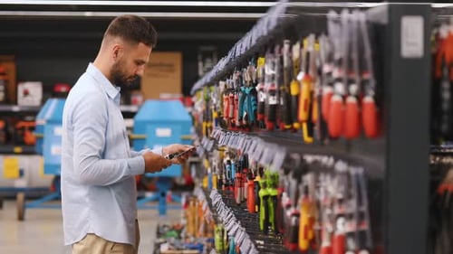 A customer in a hardware store chooses tools
