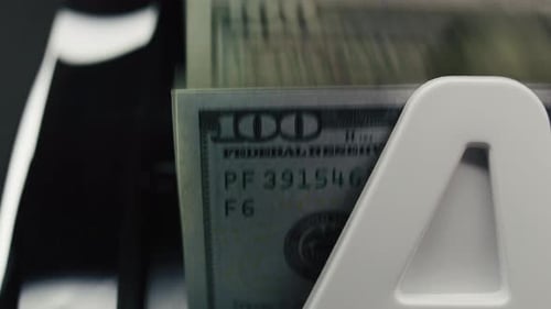 Primer plano de la máquina contadora de efectivo que cuenta billetes de cien dólares