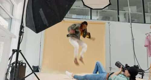 Fashion photographer, model and black man jump in studio, backstage or backdrop