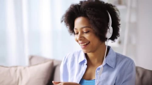 Woman with headphones listening to music indoors