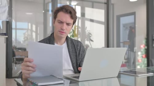 Man Celebrates Success at Office Desk