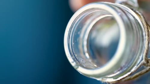 Gros plan d'une bouteille en verre déversant du jus frais.
