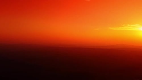 Minimalist sunset sky with deep orange and red gradient haze.