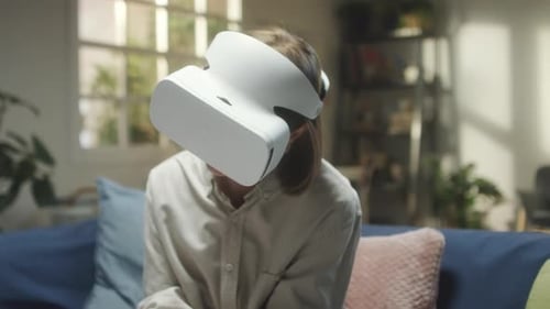 Woman Plays VR Game Using Headset at Home