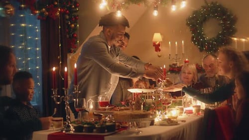 African American Man Cuts Turkey at Family Christmas Dinner