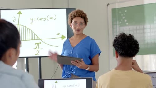 Teaching math, woman using tablet and explaining graph to students in high school