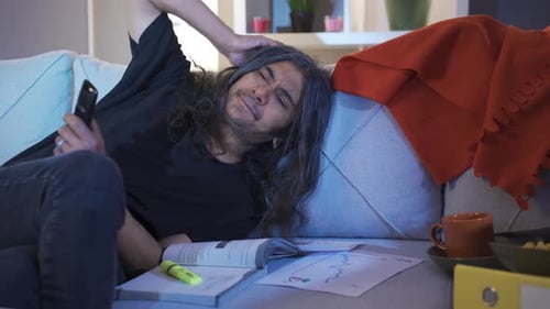 Person Falling Asleep on Couch Looking at Phone