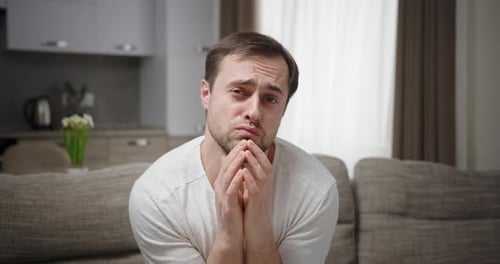 Sad Man Begging and Pleading on Couch