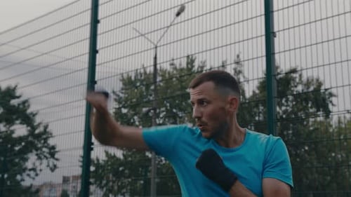 Athletic Man Boxing Punches in Outdoor Urban Setting
