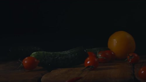 Fresh organic colorful vegetables falling on wooden table, close-up view