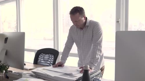 Man reviews blueprints in modern office space