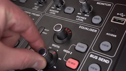 A Sound Engineer Adjusts Frequencies on a Digital Audio Mixer