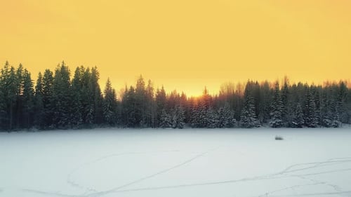 Golden Sunset Over Snow-Covered Field in Winter