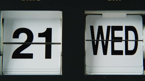 Closeup Flip Clock Calendar Switching Panels with Black Digits Macro View Date