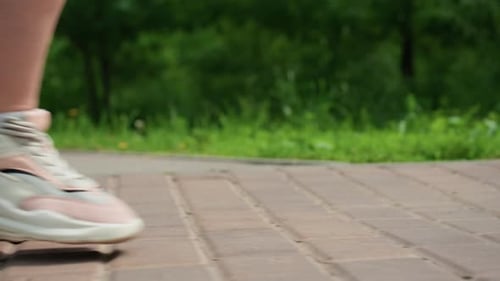 Close Up Side Leg View Of Lady Strolling Along Brick Path In Park