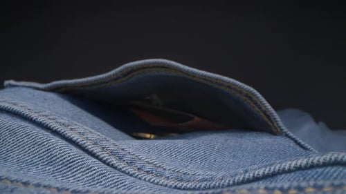 Slow motion view of camera coming to the jeans pocket. shot of money in the pocket. Probe lens, stud