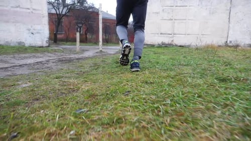 Jambes d'un jeune sportif courant le long d'un sentier rural par temps de pluie Pieds masculins d'un coureur sportif faisant du jogging