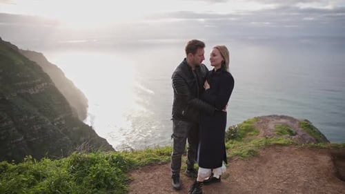 Romantic Couple Embracing on Cliff at Sunset