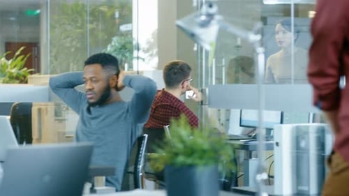 Busy International Office, Beautiful Hispanic Woman Working at Her Desk on a Laptop, in the Backgro