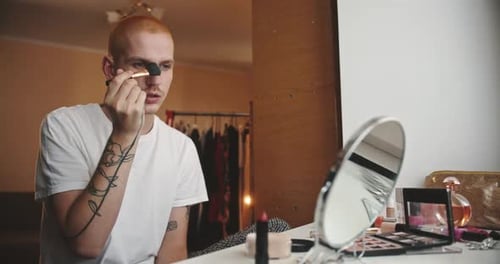 Young Adult Applying Makeup with a Brush Indoors