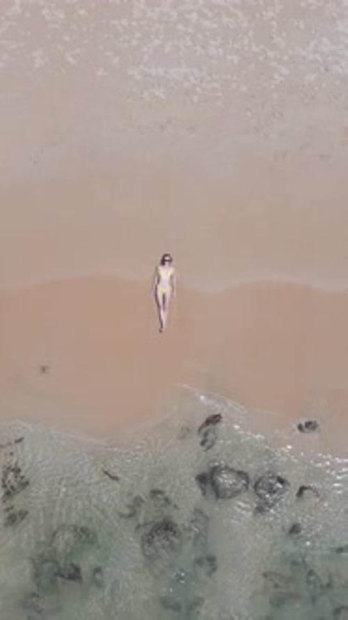 Kaukasische Frau im Bikini liegt im Urlaub an der Küste