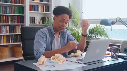 Frustrated Man Struggles With Laptop in Office