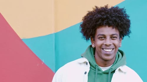 Smiling Young Adult with Curly Hair in Urban Setting