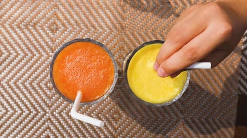 Stirring Refreshing Fruit Smoothie with Straw