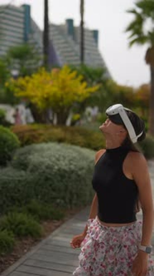 Woman Uses VR Headset on City Boardwalk