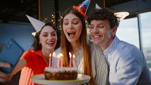 Cheerful Businesswoman Blowing Candles on Birthday Cake at Office Party Closeup