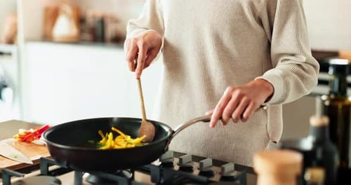 Woman Cooking Vegetables in Frying Pan at Home