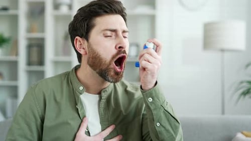 Man Coughs and Uses Inhaler Indoors