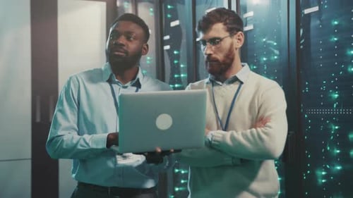 Data Technicians Working in Server Room with Laptop