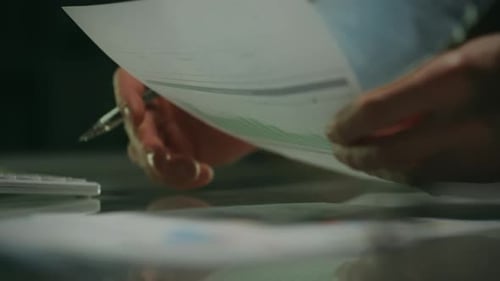 Altura. Um analista masculino com roupas clássicas analisa de forma inteligente os gráficos de lucros em uma sala de reuniões