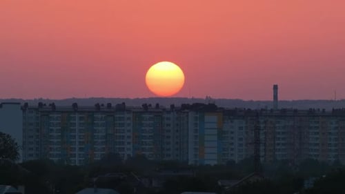 Evening Landscape with Bright Setting Sun Over Distant City High Rise Buildings at Sunset