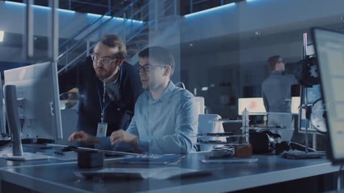 Der Entwicklungsingenieur für Elektronik verwendet den PC, spricht mit dem Manager und zeigt Projektdetails.