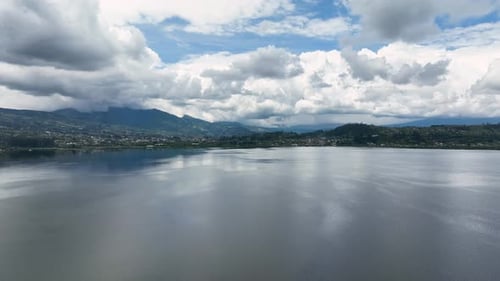Wide angle shot of scenic landscape of fluffy clouds over mountains and sea during daytime. Aerial s