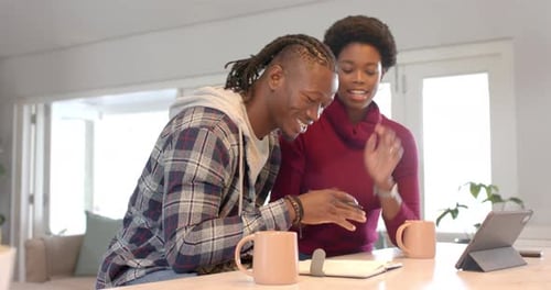 Adults Smiling and Looking at Tablet at Table