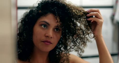 Attractive Woman with Curly Hair Styling her Hair
