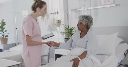 Nurse Using Tablet With Patient in Hospital Room